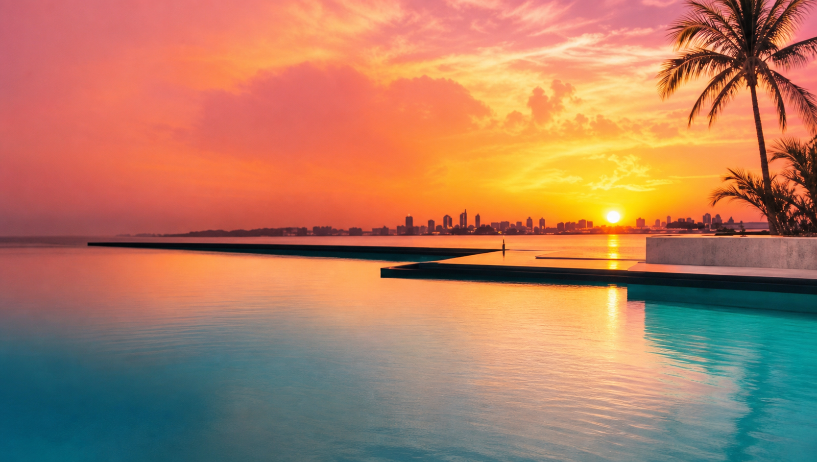 A coral-and-turquoise waterfront sunset with palms